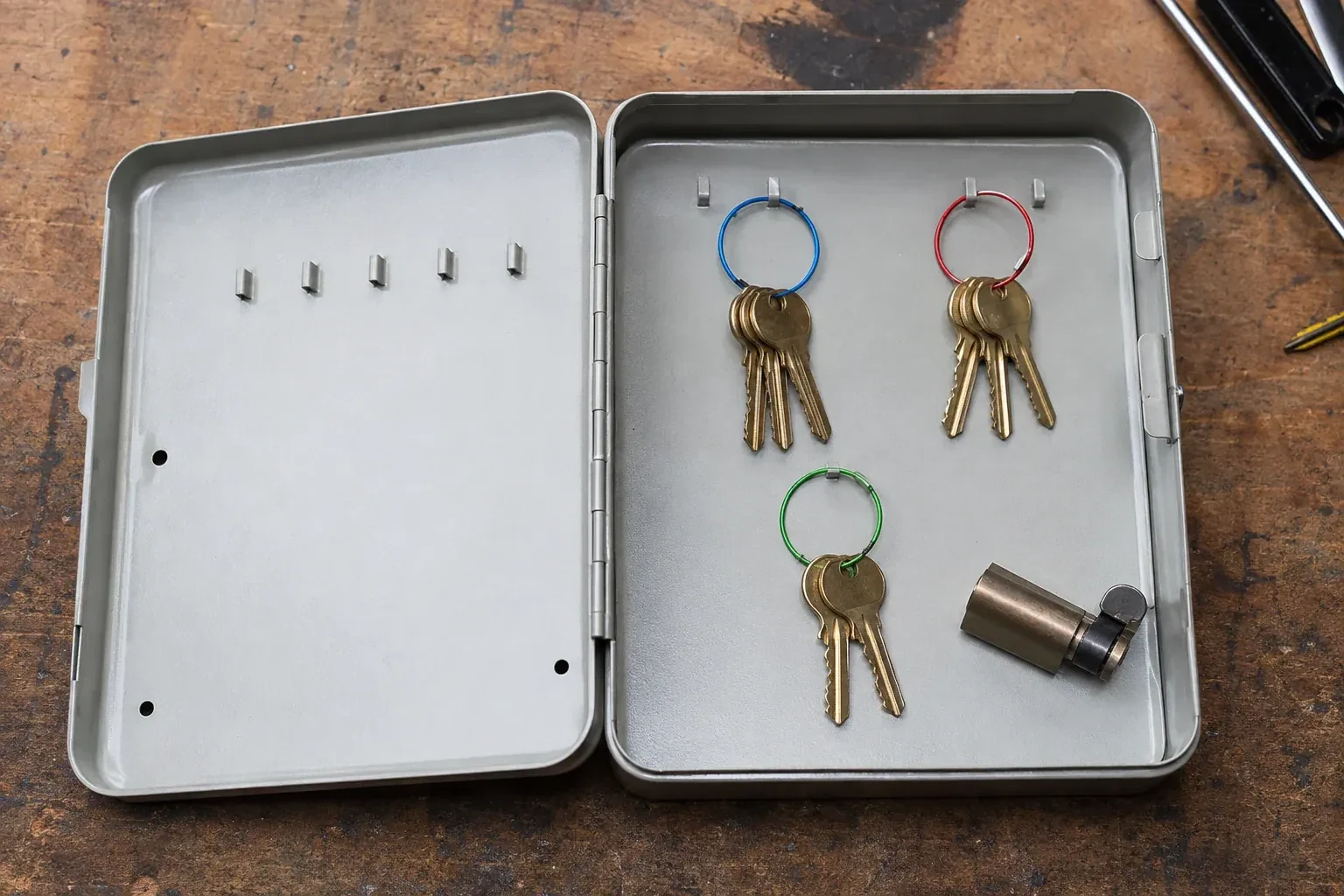 Three groups of keys on colored rings in an open metal key cabinet. — Master Key System Design, Haldimand County